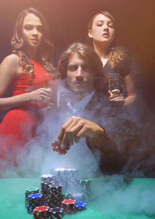 fortunate gambler surrounded by seductive elegant womenの写真素材