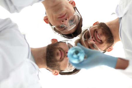 closeup.a group of scientists looks at the liquid in the beakerの写真素材