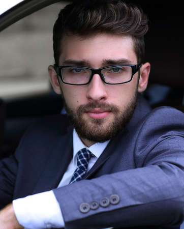 businessman in suit driving his luxurious car.