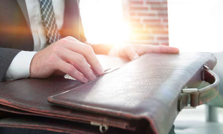 businessmans hand with suitecase in a modern officeの写真素材