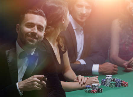 Man with cigar looking up from poker game in casinoの写真素材
