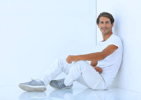 pensive boy sitting near the wallの写真素材