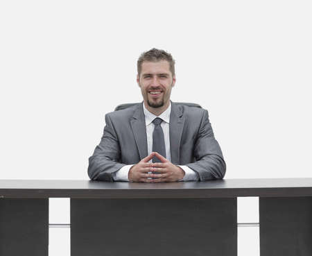 confident businessman sitting behind a Desk. isolated on white.の写真素材