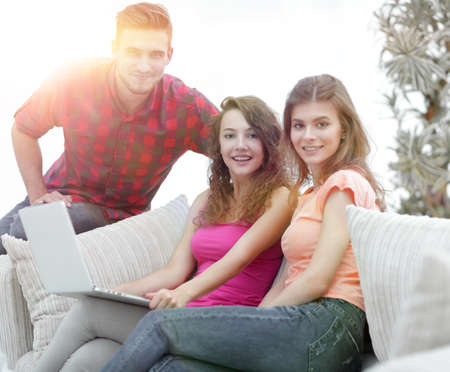 group of young people sitting on the couch in the living room.の写真素材