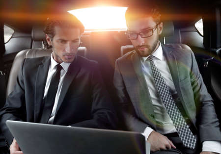 business partners sitting in a luxury carの写真素材