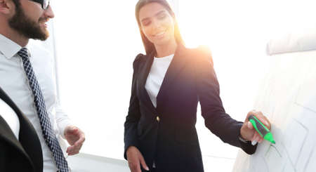 business woman pointing with a marker on the flipchartの写真素材