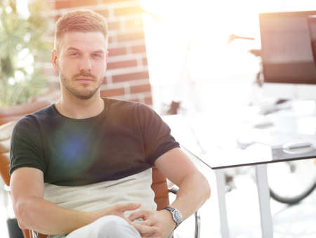 confident young man sitting at his workplaceの写真素材