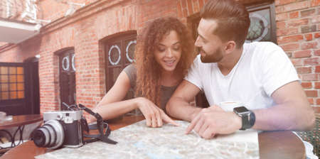 Couple in an outdoor cafe using map and planning itineraryの写真素材