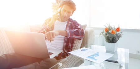 modern man working with financial documents in living room