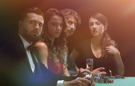 side view of group of people playing poker together in casinoの写真素材