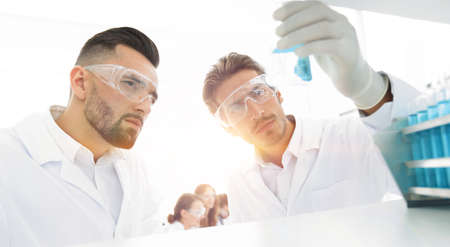 closeup. scientist and assistant studying the solution in the glの写真素材
