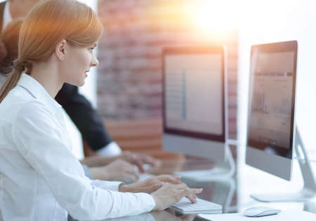 employees working on personal computers with financial dataの写真素材