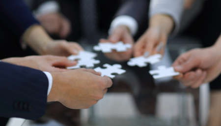 Business people holding jigsaw puzzle.