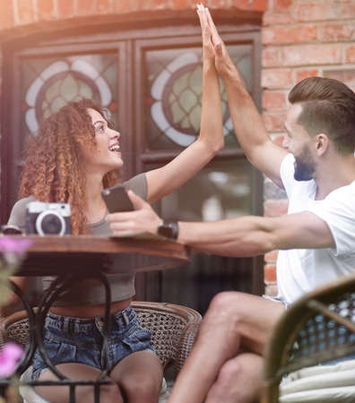 Portrait of a young  couple sitting down at a cafe terraceの写真素材