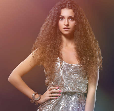 Beautiful brunette woman with beauty long curly hair.