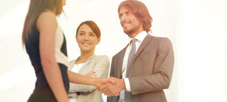 Businesspeople  shaking hands against room with large window looの写真素材