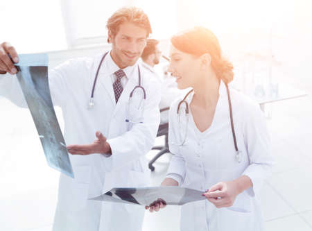 Male surgeon with nurse examining x-ray report