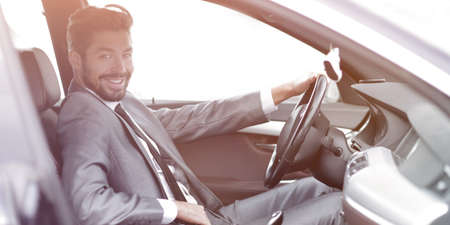 Handsome businessman in the drivers seat in his carの写真素材