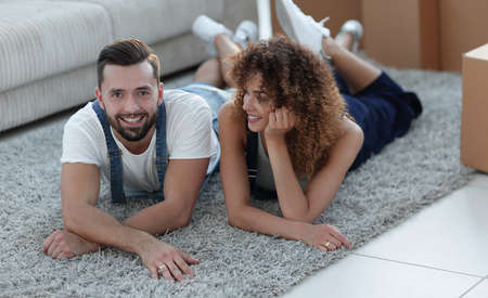 Happy couple lies on the floor in a new apartment