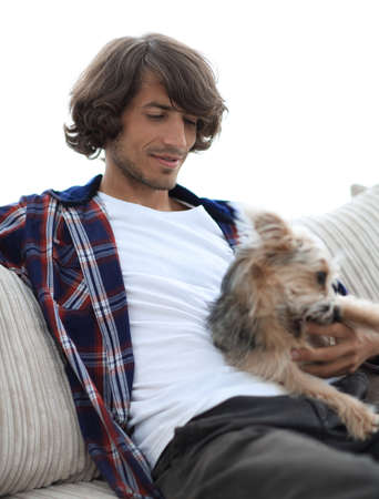stylish guy sitting on the couch with his dog.