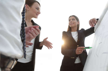 business woman pointing with a marker on the flipchart