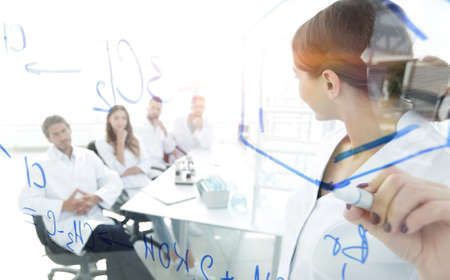 view through the transparent Board. female biochemist makes a researchの写真素材