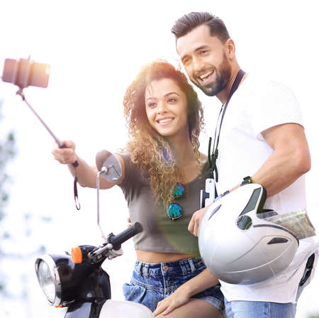 Male and female on motor scooters in a town.の写真素材
