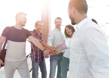 successful team of designers clasped their palms together.の写真素材