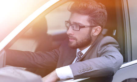 businessman in suit driving his luxurious car.
