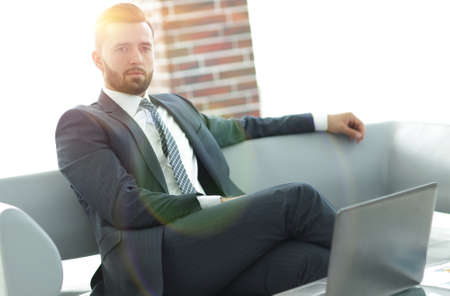 Portrait of a successful businessman sitting in the office lobbyの写真素材