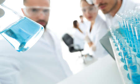 closeup. scientist and assistant studying the solution in the glass tubeの写真素材