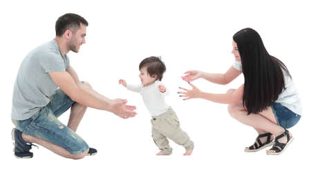 little boy making  first steps with the help of parentsの写真素材