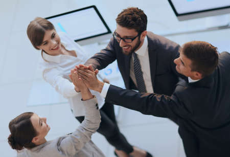successful business team giving each other a high-five, standing in the officeの写真素材