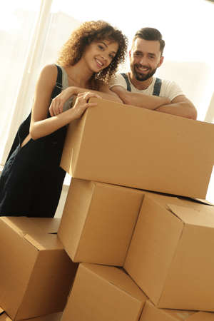 Happy couple honeymooners standing near boxes