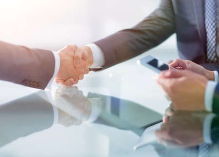 Two confident businessmen shaking hands during a meeting in the