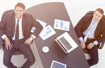 discussing the terms of a financial contract,sitting behind a Desk and looking at cameraの写真素材