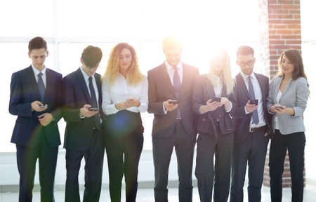 business team looking to smartphone in officeの写真素材