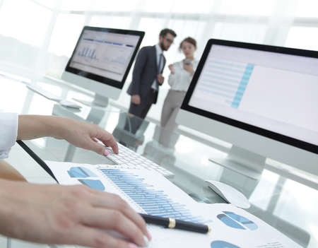 close-up of a business woman working with financial charts in a modern office