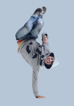 Funny cheerful happy man jumping in air over gray backgroundの写真素材