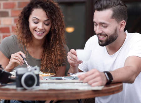 Young couple enjoying coffee at a street cafe and  laughingの写真素材