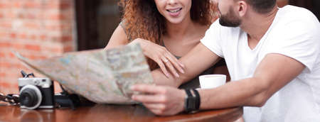 A picture of  tourists looking at map in a cafe