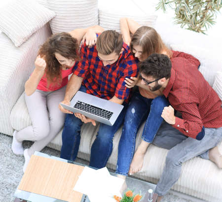 group of friends looking at the photo on the laptop.の写真素材