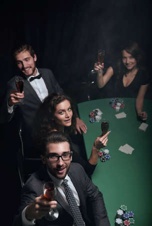 Group of young rich people is playing poker in the casino