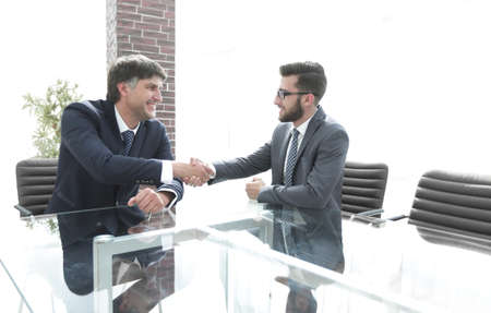 Business partners shake hands after discussing the contract
