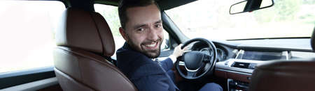 Successful man sitting behind the wheel of a prestigious carの写真素材