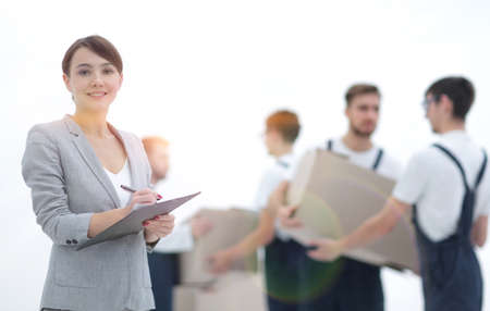 Woman manager holding clipboard on blurred background with moverの写真素材