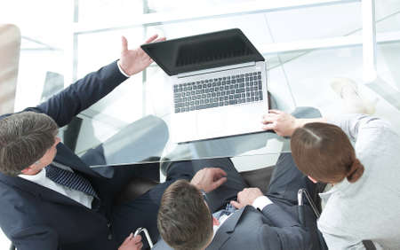 Three business people, meeting around a boardroom tableの写真素材
