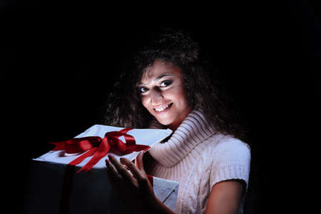 Happy young woman opening a Christmas presentの写真素材