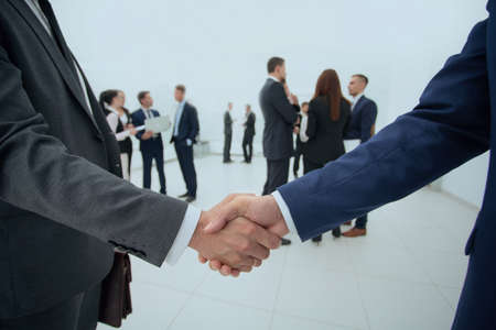 closeup of handshake of business partners on the background of business teamの写真素材