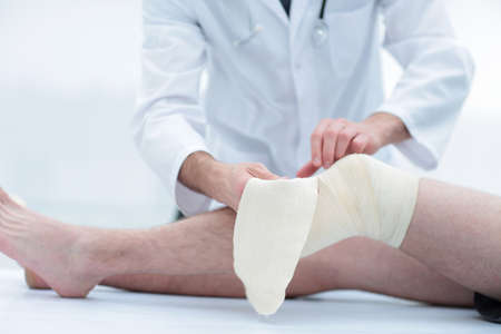doctor bandaging patient kneeの写真素材